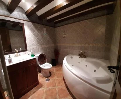 Baño con una amplia bañera de hidromasaje privada de uno de los apartamentos del establecimiento.