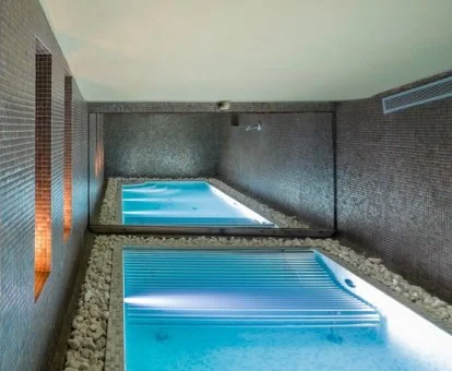 Piscina cubierta con elementos de hidroterapia del spa del hotel.