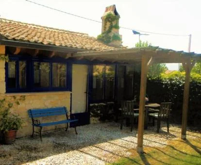 Acogedora casa rural con terraza y mobiliario exterior.