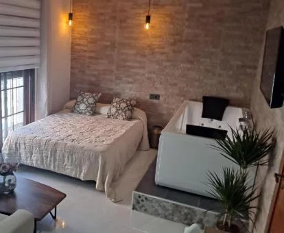 Dormitorio con una gran bañera de hidromasaje privada junto a la cama, ideal para parejas.