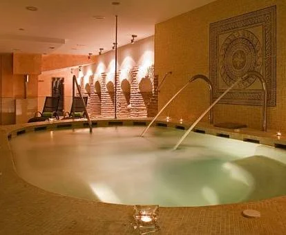 Piscina cubierta con elementos de hidroterapia del spa del hotel.