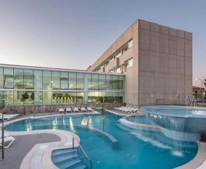 Espectacular piscina con elementos de hidroterapia al aire libre del hotel.