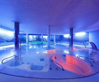 Piscina cubierta con elementos de hidroterapia del spa del hotel.