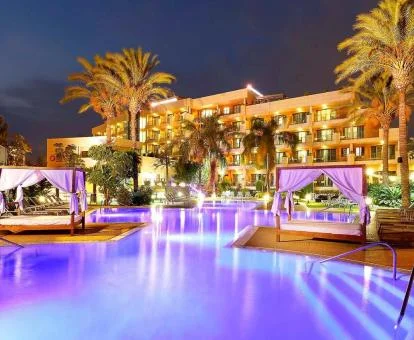 Edificio de este hotel solo para adultos con piscina exterior y solarium con camas balinesas y palmeras.
