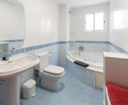 Baño con bañera de hidromasaje privada de este acogedor apartamento.