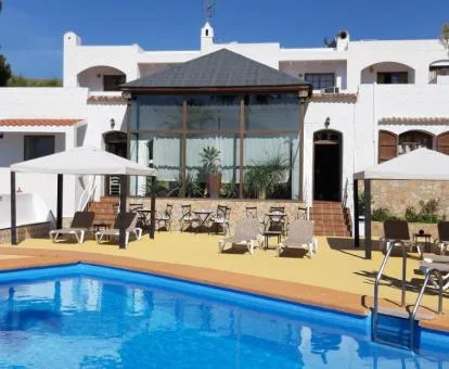 Hotel rural con piscina exterior y rodeado de naturaleza.