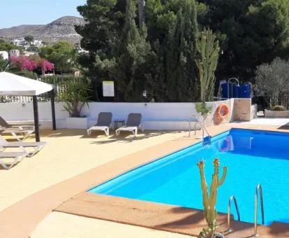 Zona exterior con piscina y tumbonas de este acogedor hotel romántico.