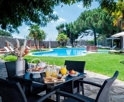 Amplios jardines con mobiliario y piscina de este hotel romántico.