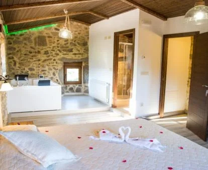 Suite Deluxe con bañera de hidromasaje cerca de la cama.