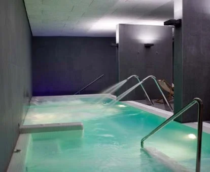 Piscina cubierta con elementos de hidroterapia del spa del hotel.