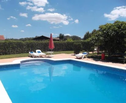 Piscina exterior rodeada de jardines de este establecimiento rural.