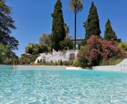 Zona exterior con piscina rodeada de jardines de este hotel rural.