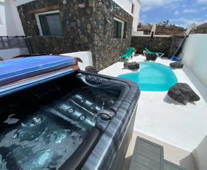 Zona exterior con piscina privada y jacuzzi del apartamento deluxe del alojamiento.