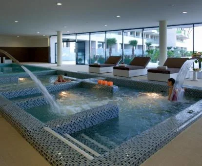 Amplia zona de aguas con hidroterapia y vistas al exterior del spa.