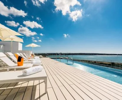 Fabulosa terraza solarium con piscina y vistas al mar del hotel.