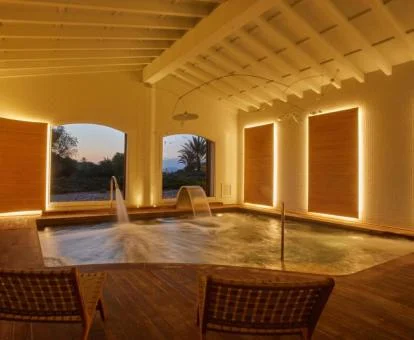 Piscina con chorros de hidroterapia y vistas a la naturaleza del spa del hotel.