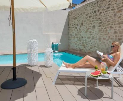 Mujer disfrutando de la acogedora piscina con chorros del hotel.