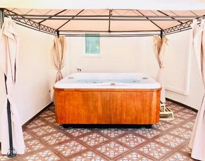 Foto del jacuzzi exterior que tienes bajo un pérgola en la Suite Real con vistas al mar y jacuzzi del Flamingo Suites de Adeje