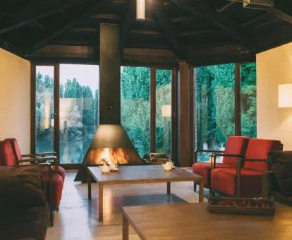 Acogedora zona de estar con chimenea y vistas al jardín de este coqueto hotel boutique.