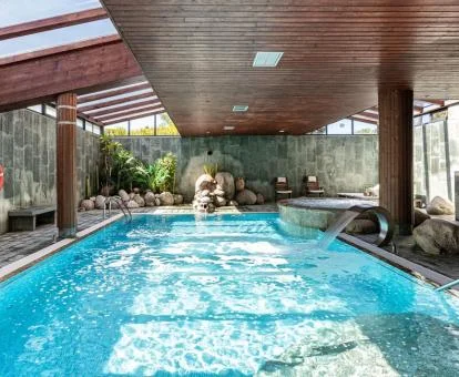 Preciosa piscina cubierta con elementos de hidroterapia del spa del hotel.