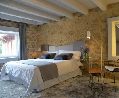 Una de las habitaciones modernas con paredes de piedra a la vista del hotel.