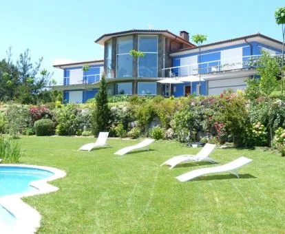 Hotel con encanto con piscina y amplios jardines con tumbonas.