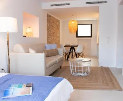 Interior de uno de los coquetos apartamentos de este establecimiento, con zona de estar, cama doble y comedor interior.