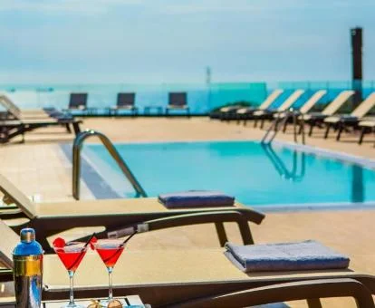 Piscina con solarium y tumbonas del hotel.