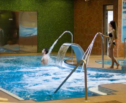 Pareja disfrutando de la zona de hidroterapia del spa de este hotel.