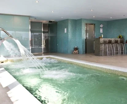 Piscina cubierta con elementos de hidroterapia del spa del hotel.