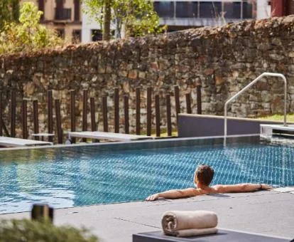 Hombre disfrutando de la preciosa piscina de este hotel con encanto.