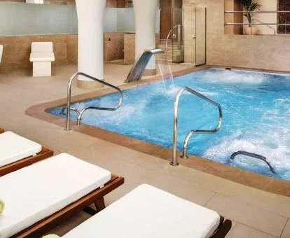 Piscina cubierta con elementos de hidroterapia del spa del hotel.