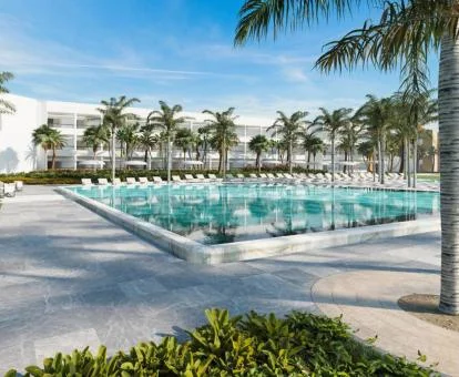 Espectacular hotel con una gran piscina al aire libre rodeada de palmeras.