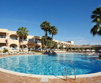 Gran piscina al aire libre con palmeras y tumbonas de este precioso hotel solo para adultos.