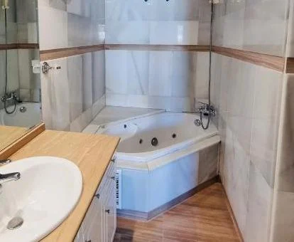 Bañera de hidromasaje privada en el baño de este moderno apartamento.