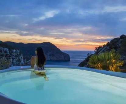 Mujer disfrutando de las espectaculares vistas desde la piscina del hotel.