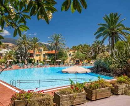 Exteriores de este maravilloso hotel con una gran piscina exterior rodeada de vegetación.