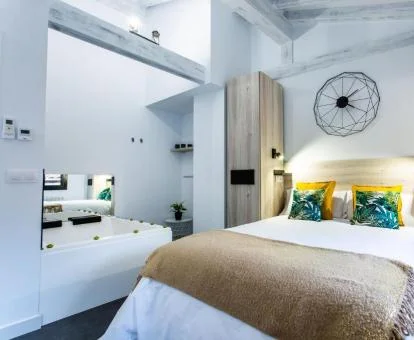 Precioso dormitorio con bañera de hidromasaje privada junto a la cama de uno de los estudios de este establecimiento.