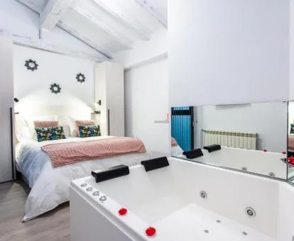Dormitorio con jacuzzi privado junto a la cama de uno de los apartamentos del establecimiento.
