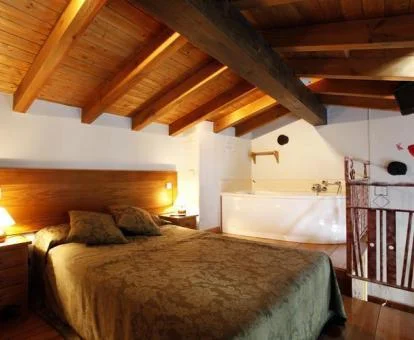 Dormitorio con bañera de hidromasaje privada junto a la cama del apartamento ático de este establecimiento.