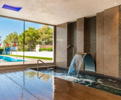 Piscina con chorros de hidroterapia y vistas al exterior del spa del hotel.