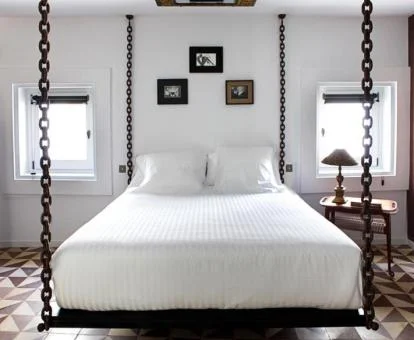 Una de las coquetas habitaciones de este alojamiento solo para adultos con cama doble que cuelga del techo.