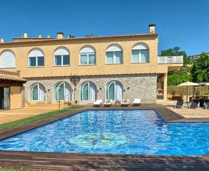 Precioso hotel rural con amplia piscina al aire libre y terraza con zonas de estar.