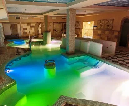 Piscina cubierta con elementos de hidroterapia del spa del hotel.