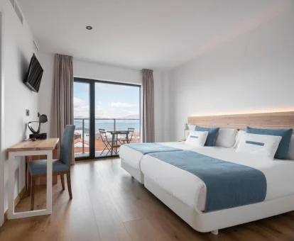 Una de las modernas habitaciones con balcón amueblado y vistas al mar del hotel.
