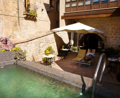 Terraza con mobiliario exterior con piscina de este hotel solo para adultos.