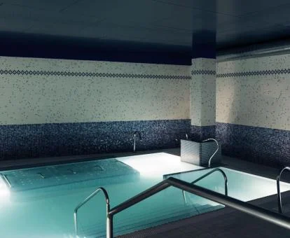 Piscina cubierta con elementos de hidroterapia del spa del hotel.
