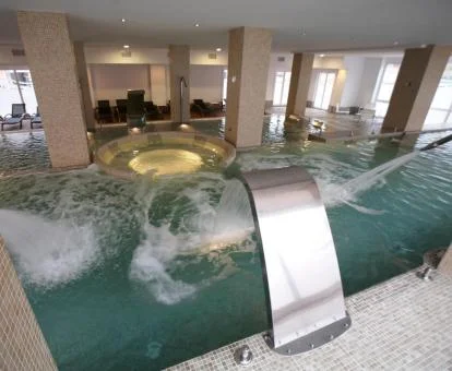 Piscina cubierta con elementos de hidroterapia del spa del hotel.