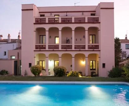 Fachada de este precioso hotel con piscina rodeado de edificios.