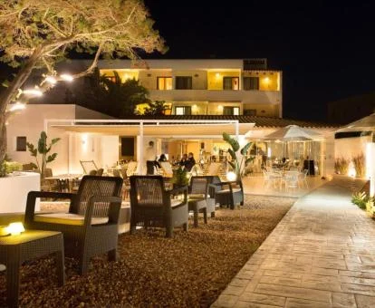 Precioso hotel solo para adultos con bellos jardines y terraza con zona de estar al aire libre con iluminación nocturna.